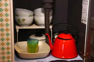 a red tea kettle and a cup on a shelf at Kingyosou in Tokyo