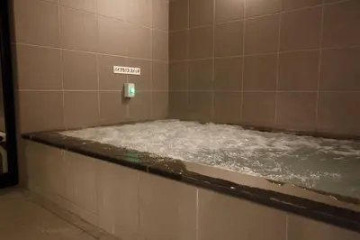 a bath room with a tub filled with water at The Nell Ueno Okachimachi in Tokyo