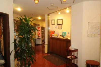 a hallway with a reception desk and a potted plant at Hotel Kangetsuso in Tokyo