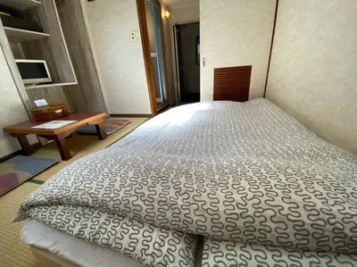 a bedroom with a large bed in a room at Asakusa Ryokan Toukaisou in Tokyo
