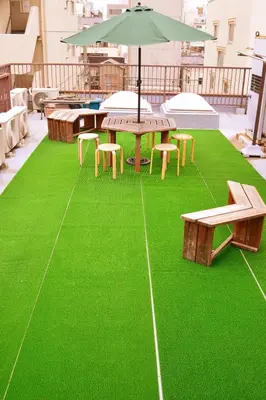 a patio with a table and benches and an umbrella at Asakusa Ryokan Toukaisou in Tokyo