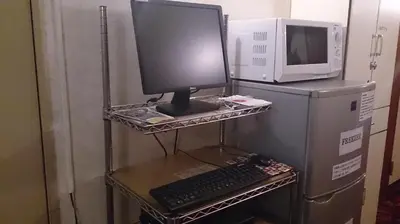a computer sitting on a shelf next to a microwave at Asakusa Ryokan Toukaisou in Tokyo