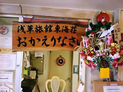 a sign with asian writing on the wall of a room at Asakusa Ryokan Toukaisou in Tokyo