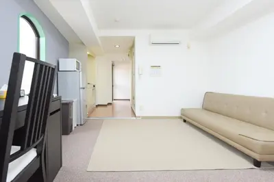 a living room with a couch and a kitchen at HIROKI Building in Tokyo