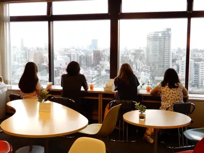 a group of women sitting at tables in a restaurant looking out the window at Tokyo Central Youth Hostel in Tokyo