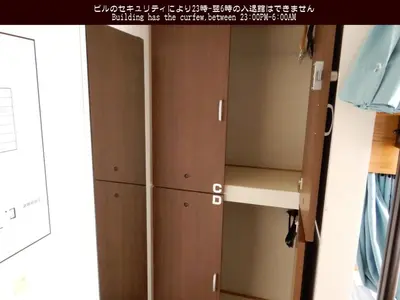 a bedroom closet with wooden doors and shelves at Tokyo Central Youth Hostel in Tokyo