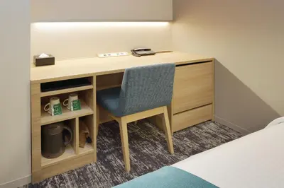 a desk with a chair next to a bed at Keio Presso Inn Tokyo Kudanshita in Tokyo