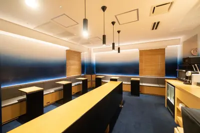 a restaurant with a long table and benches at Hotel New Shohei in Tokyo
