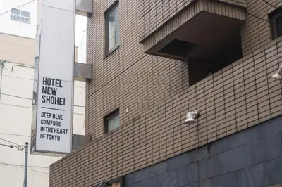 a building with a sign on the side of it at Hotel New Shohei in Tokyo