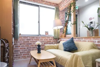 a living room with a couch and a brick wall at nestay inn tokyo senju in Tokyo