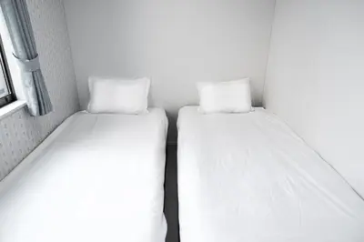 two beds sitting next to each other in a room at nestay inn tokyo senju in Tokyo