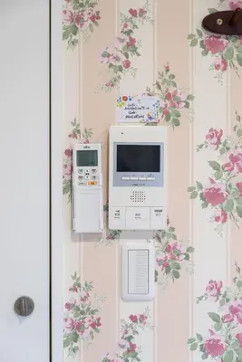 two machines are on a wall with flowers at nestay inn tokyo senju in Tokyo