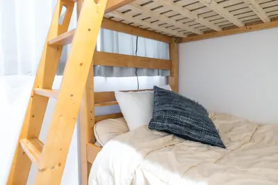 a bunk bed in a room with a ladder at nestay inn tokyo senju in Tokyo