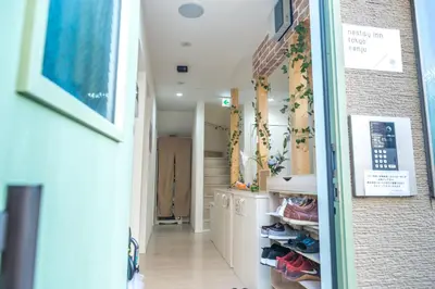 a hallway of a house with shoes on a shelf at nestay inn tokyo senju in Tokyo
