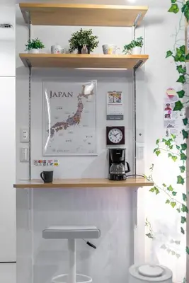 a shelf above a table with a stool at nestay inn tokyo senju in Tokyo