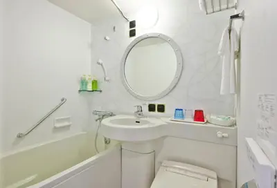 a white bathroom with a sink and a mirror at Tokyo Bay Maihama Hotel First Resort in Urayasu