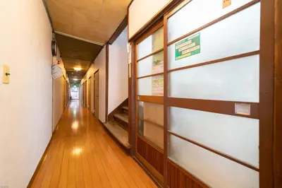 a hallway with a door in a building at Ryokan Nakadaya in Tokyo
