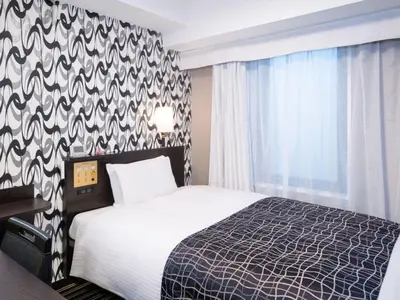 a bedroom with a bed and a black and white patterned wall at APA Hotel Tokyo Kudanshita in Tokyo
