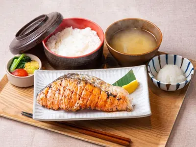 a plate of food with a fish and rice and chopsticks at APA Hotel Tokyo Kudanshita in Tokyo