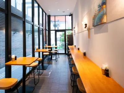 a row of tables in a restaurant with windows at APA Hotel Tokyo Kudanshita in Tokyo