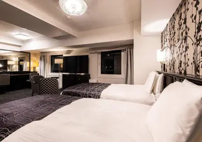 a hotel room with two beds and a desk at APA Hotel & Resort Tokyo Bay Shiomi in Tokyo