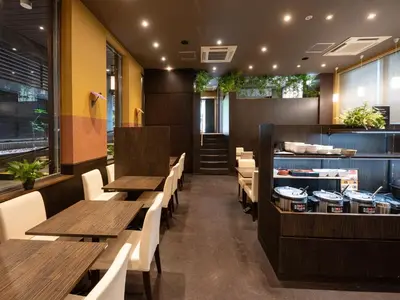 a restaurant with wooden tables and white chairs at APA Hotel Asakusa Kuramae in Tokyo