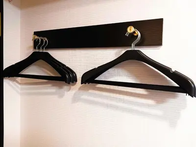 two black hangers hanging on a wall at APA Hotel Ikebukuro Eki Kitaguchi in Tokyo