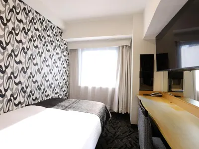 a hotel room with a bed and a desk at APA Hotel Ikebukuro Eki Kitaguchi in Tokyo