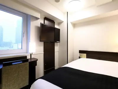 a hotel room with a bed and a window at APA Hotel Akasaka Mitsuke in Tokyo