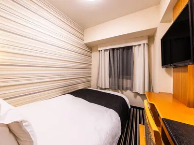 a hotel room with a bed and a television at APA Hotel Nishiazabu in Tokyo