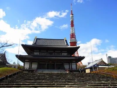 a building with a tower in the background with stairs at APA Hotel Shimbashi Onarimon in Tokyo