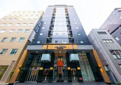 a tall building with a sign in front of it at APA Hotel Ningyocho Ekikita in Tokyo