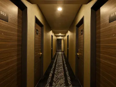 a corridor of a hotel with wooden doors at APA Hotel Kodemmacho Ekimae in Tokyo