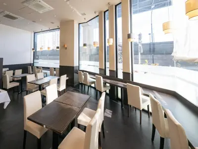 a restaurant with tables and chairs and windows at APA Hotel Nihonbashi Hamacho Ekiminami in Tokyo