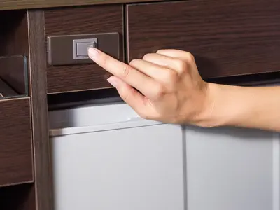 a hand is unlocking a cabinet with a drawer at APA Hotel Nihonbashi Hamacho Ekiminami in Tokyo