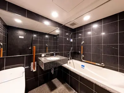 a bathroom with a sink and a bath tub at APA Hotel Hatchobori Ekiminami in Tokyo