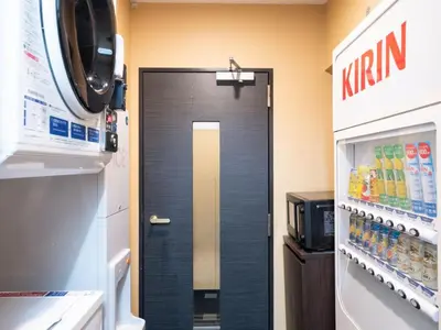a black door in a kitchen with a drink refrigerator at APA Hotel Tsukiji Ekiminami in Tokyo