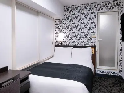 a bedroom with a bed and a black and white wallpaper at APA Hotel Tsukiji Ekiminami in Tokyo