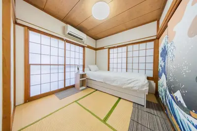 a small room with a bed and two windows at Ikebukuro no Yado detached house in Tokyo