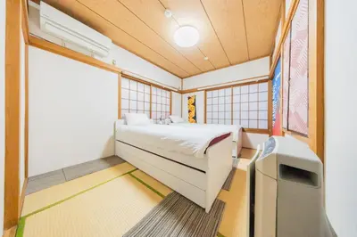 a bedroom with a bed and a tv in it at Ikebukuro no Yado detached house in Tokyo