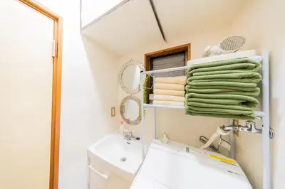 a bathroom with a sink and a towel rack at Ikebukuro no Yado detached house in Tokyo