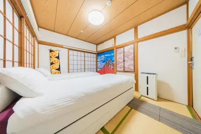 a bedroom with a large bed in a room with windows at Ikebukuro no Yado detached house in Tokyo