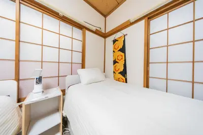 a small room with two beds and a lamp at Ikebukuro no Yado detached house in Tokyo