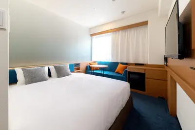 a hotel room with a bed and a television at Nishitetsu Inn Nihonbashi in Tokyo
