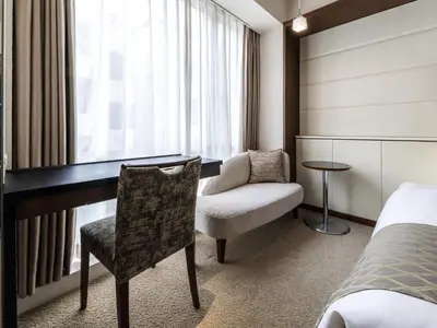 a bedroom with a desk and a chair and a bed at Solaria Nishitetsu Hotel Ginza in Tokyo
