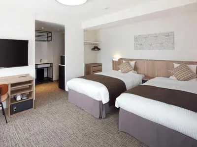 a hotel room with two beds and a flat screen tv at HOTEL MYSTAYS Kiyosumi Shirakawa in Tokyo