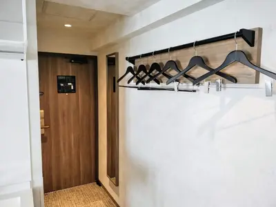 a hallway with a door and a shelf with wine bottles at HOTEL MYSTAYS Kiyosumi Shirakawa in Tokyo