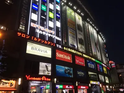 a large building with many signs on it at night at Namio Apartment 201 in Tokyo