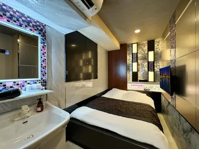 a small bedroom with a bed and a sink at Hotel Amethyst in Tokyo