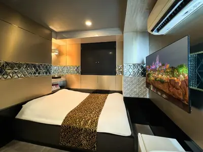 a bedroom with a bed and a flat screen tv at Hotel Amethyst in Tokyo